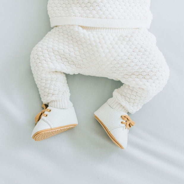 white baby shoes on a baby