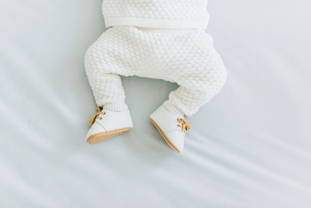 white baby shoes on a baby