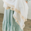 Detail shot of tassels on blanket on baby. 