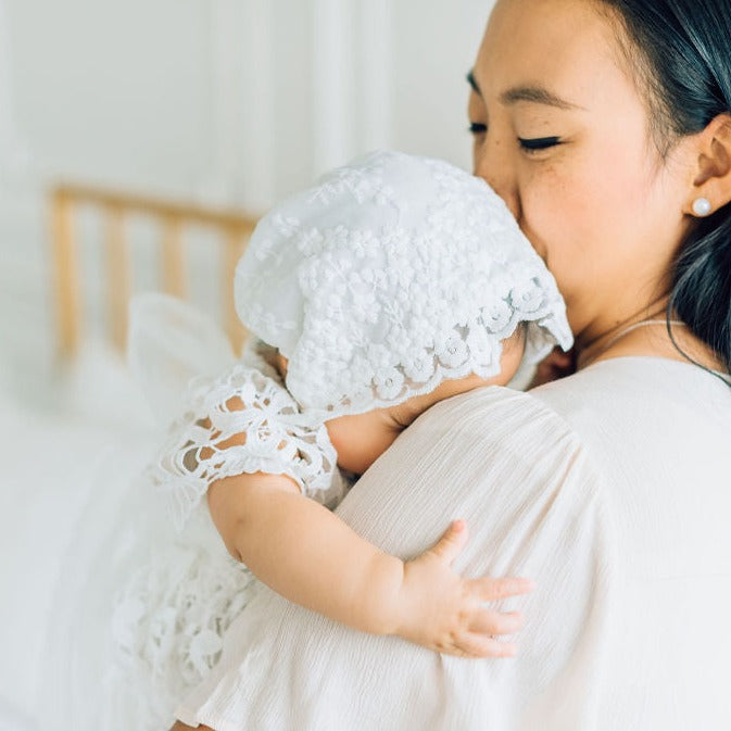 baby in christening blessing bonnet in moms arms