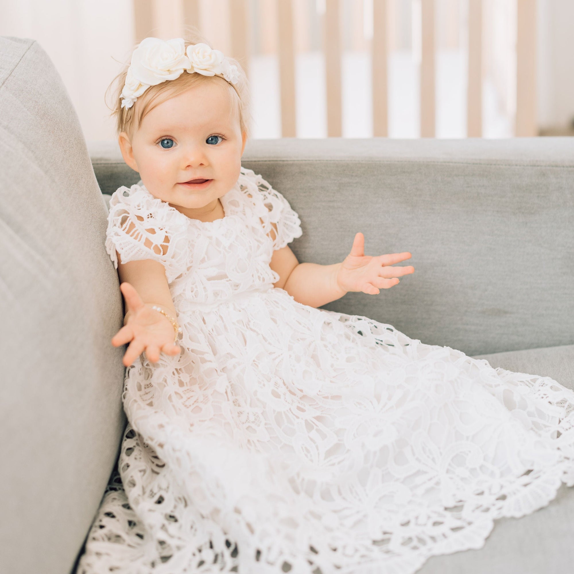 baby girl model wearing white lace christening dress.